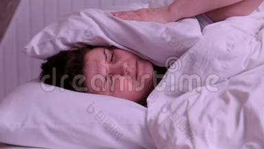 女人睡觉时被闹哄哄的房间邻居用枕头捂住耳朵，醒来后躺在床上受苦